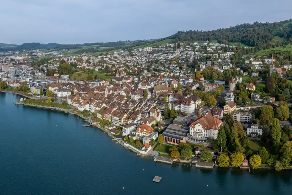 Aerial view of densely built luxury villas along a Swiss lake shore, illustrating limited waterfront
